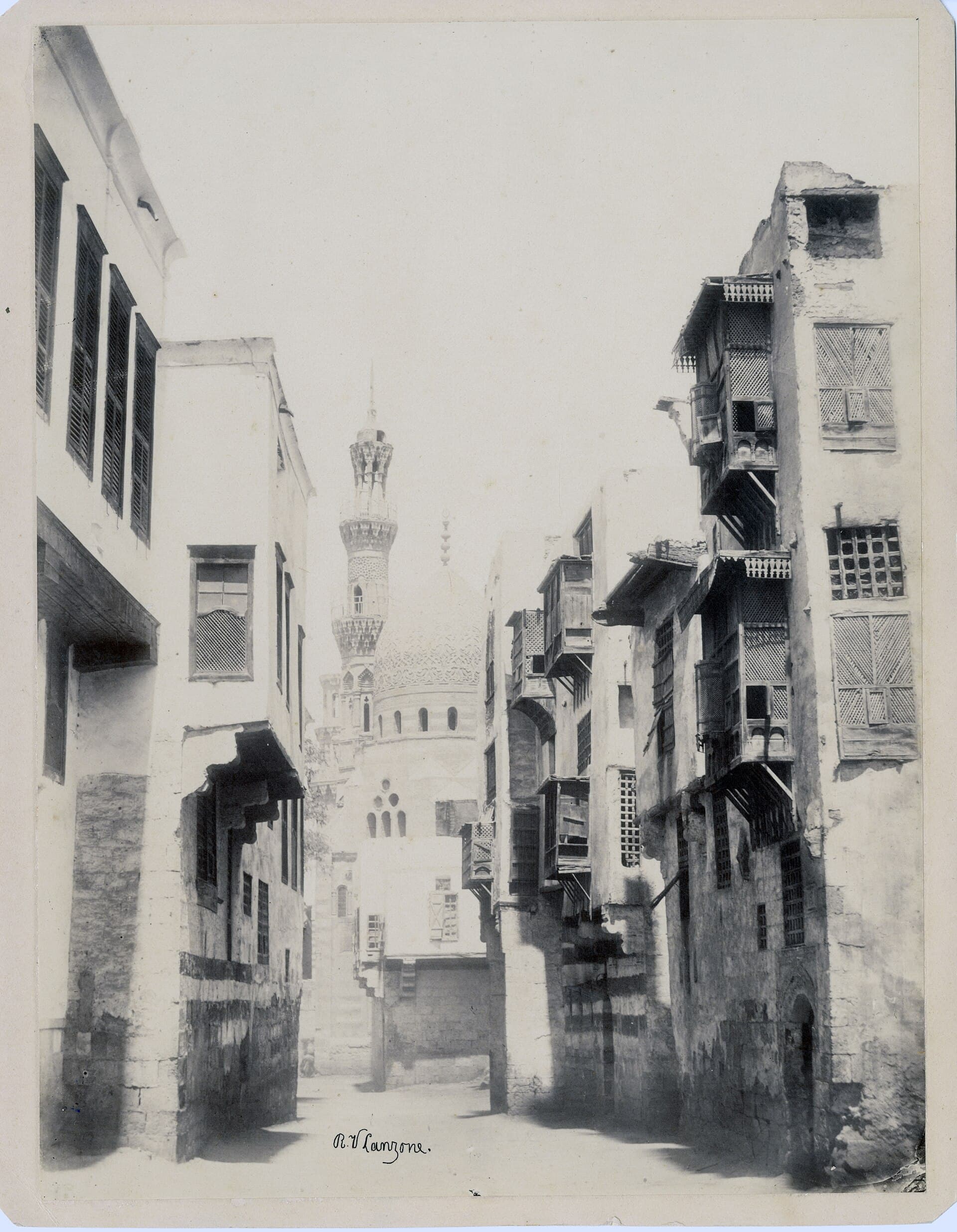 A lane of mashrabiya houses below a carved minaret, 1870. Photograph by R. V. Lanzone.
